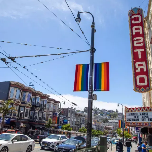 The Castro neighborhood of San Francisco, with the Castro Theater sign and rainbow flags in the foreground.